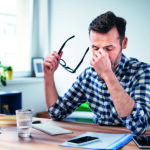 Frustrated, overworked freelancer working from home office